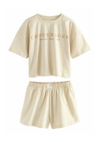 Ensemble de détente en coton beige comprenant un haut court à manches courtes portant l'inscription "COPENHAGUE Football Dept. 1995" et un short assorti à taille élastique.