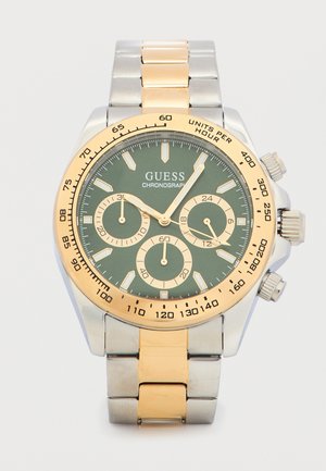 Montre-bracelet chronographe Guess en métal bicolore avec cadran vert, trois sous-cadrans, lunette dorée et graduations de tachymètre sur la bordure extérieure.