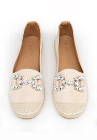Espadrilles in suede beige con suola in juta intrecciata, caratterizzate da un accento di catena gioiello sulla parte anteriore. Design con punta semi-tonda.