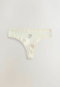 Trusse med flødefarvet blondekant og et lille, farverigt blomstermønster i midten foran.