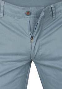 Lichtblauwe broek met een rits en knoopsluiting, en gedetailleerde stiksels. Gemaakt van zachte, gladde stof met een casual pasvorm.