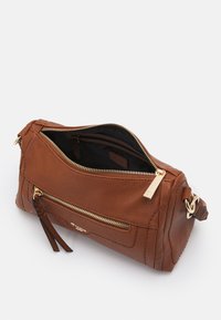 Brązowa skórzana torebka o teksturowanej powierzchni. Posiada wiele zamykanych na zamek komór, złote okucia oraz odpinany pasek na ramię.