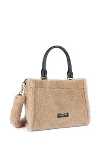 Borsa in pelliccia artificiale beige con manici e tracolla in pelle nera. Presenta una forma rettangolare e un'etichetta del marchio sul davanti. Texture morbida.