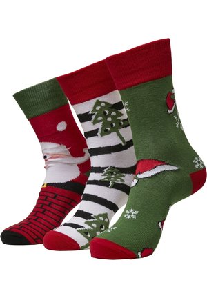 Drei Paare festlicher Socken: rot mit Santa-Design, schwarz-weiß gestreift mit Tannenbäumen und grün mit Santa-Hüten und Schneeflocken.