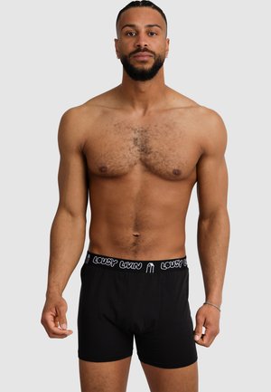 Black boxer shorts with a soft texture, features a white elastic waistband displaying the text "LOUSY LIVIN" in a repeating pattern.