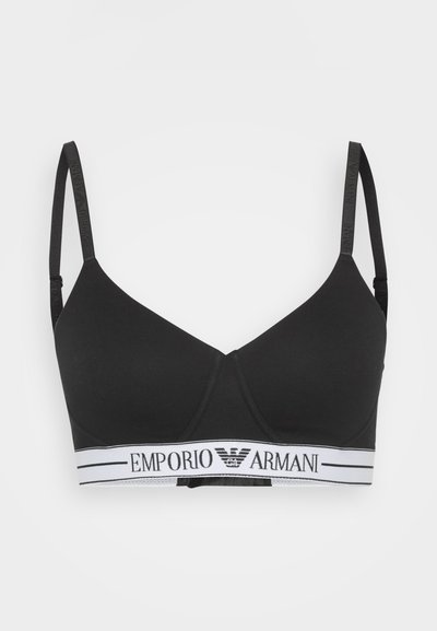 Black wireless bra made of soft fabric, featuring a plunging neckline and adjustable straps. Notable Emporio Armani logo on white band.