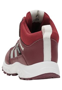 Maroon Wanderschuh mit einer strukturierten Synthetik-Oberfläche, weißem Zugband und robustem Profil. Verfügt über graue Streifen an den Seiten und einen gepolsterten Schaftrand.