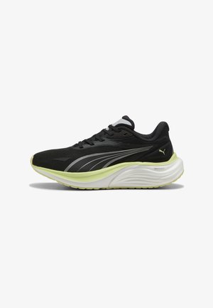 Scarpa da corsa atletica nera e giallo neon con suola imbottita bianca e striscia con logo Puma argentata sul lato.