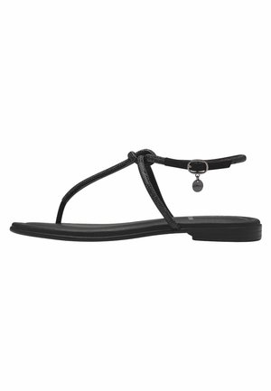 Infradito neri con design a cinturino annodato, dotati di una suola piatta e un piccolo accessorio circolare in metallo vicino alla cinghia alla caviglia.