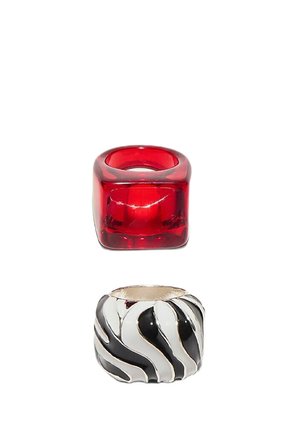 Two wide rings; one is translucent red with a rounded square shape, the other metallic with black and white zebra stripes.