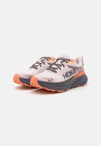 Scarpe da corsa HOKA con tomaia in rete, una combinazione di colori grigia e rosa, accenti arancioni a contrasto e una suola testurizzata per una migliore aderenza.