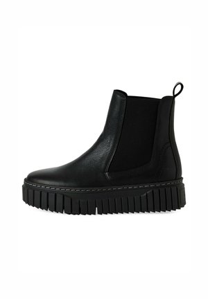 Bottines Chelsea en cuir noir avec des panneaux élastiques sur les côtés, semelle en caoutchouc épaisse et détails striés. Boucle à l'arrière pour un enfilage facile.