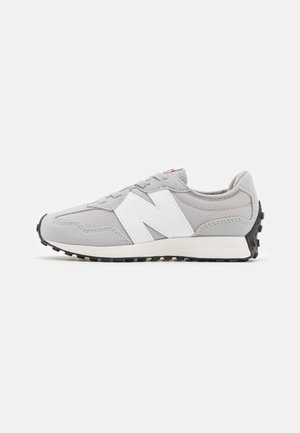 Baskets New Balance gris clair et blanc avec dessus en mesh et daim, semelle noire crantée et design à lacets vus de profil.