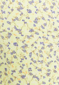 Katoenen stof met een pastelgele achtergrond en een bloemenpatroon van blauwe bloemen, bruine stelen en kleine oranje accenten.