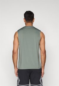 Αμάνικη αθλητική μπλούζα σε αποχρώσεις πράσινου, κατασκευασμένη από απαλό, ελαστικό ύφασμα. Διαθέτει κλασικό στρογγυλό λαιμό και άνετη εφαρμογή για άνεση.