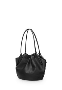 Zwarte leren emmer tas met een geplooide bovenkant, twee lange handvatten en een gladde, matte textuur. Verstevigde stiksels langs de naden.