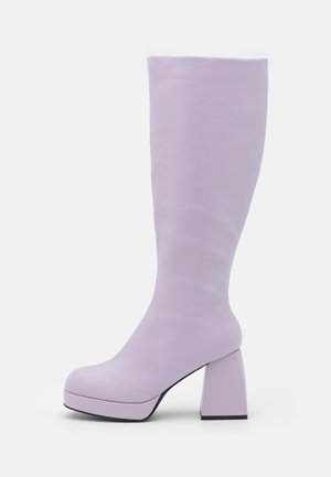 Botte haute pour femme couleur violet pastel avec un bout rond, une semelle plateforme et un talon épais carré sur fond blanc.