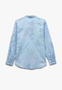 Helles blaues Longsleeve-Shirt mit floralem Stickerei, ausgeschnittenen Details, Knopfmanschetten und abgerundetem Saum. Glatter Baumwollstoff.