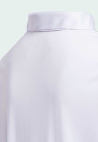 Biała koszula z tkaniny, charakteryzująca się klasycznym kołnierzykiem, gładką fakturą oraz czystym, minimalistycznym wzornictwem, bez widocznych wzorów czy akcentów.