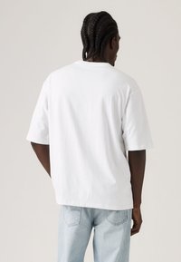 Λευκό, βαμβακερό κοντομάνικο μπλουζάκι. Άνετη εφαρμογή με λεία υφή. Ορατές ραφές και στρογγυλεμένη λαιμόκοψη. Καθημερινό σχέδιο.