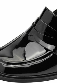 Mocassin en cuir noir brillant avec un petit talon et une bride décorative sur le cou-de-pied, orné de coutures nettes le long des coutures.