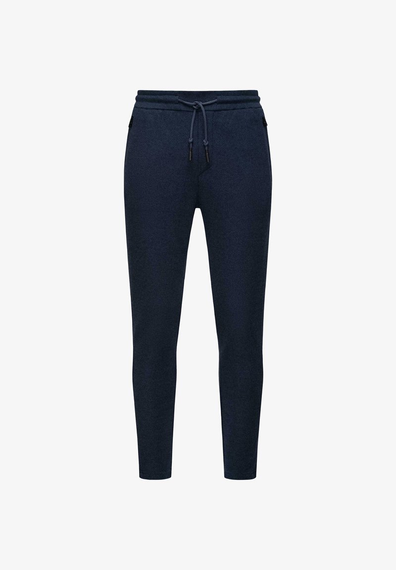 Navy blue jogger pants in a soft, textured fabric with a drawstring waist, tapering legs, and side pockets with zipper closures.