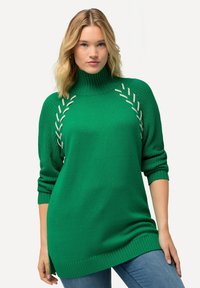 Maglione verde a collo alto lavorato a maglia con polsini e bordo a coste. Presenta cuciture a contrasto lungo le spalle. Maniche lunghe, vestibilità ampia.