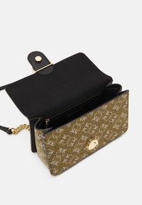 Borsa in oro e nero con superficie testurizzata, tracolla a catena, chiusura a linguetta magnetica e scomparto con cerniera. Presenta motivi intricati.