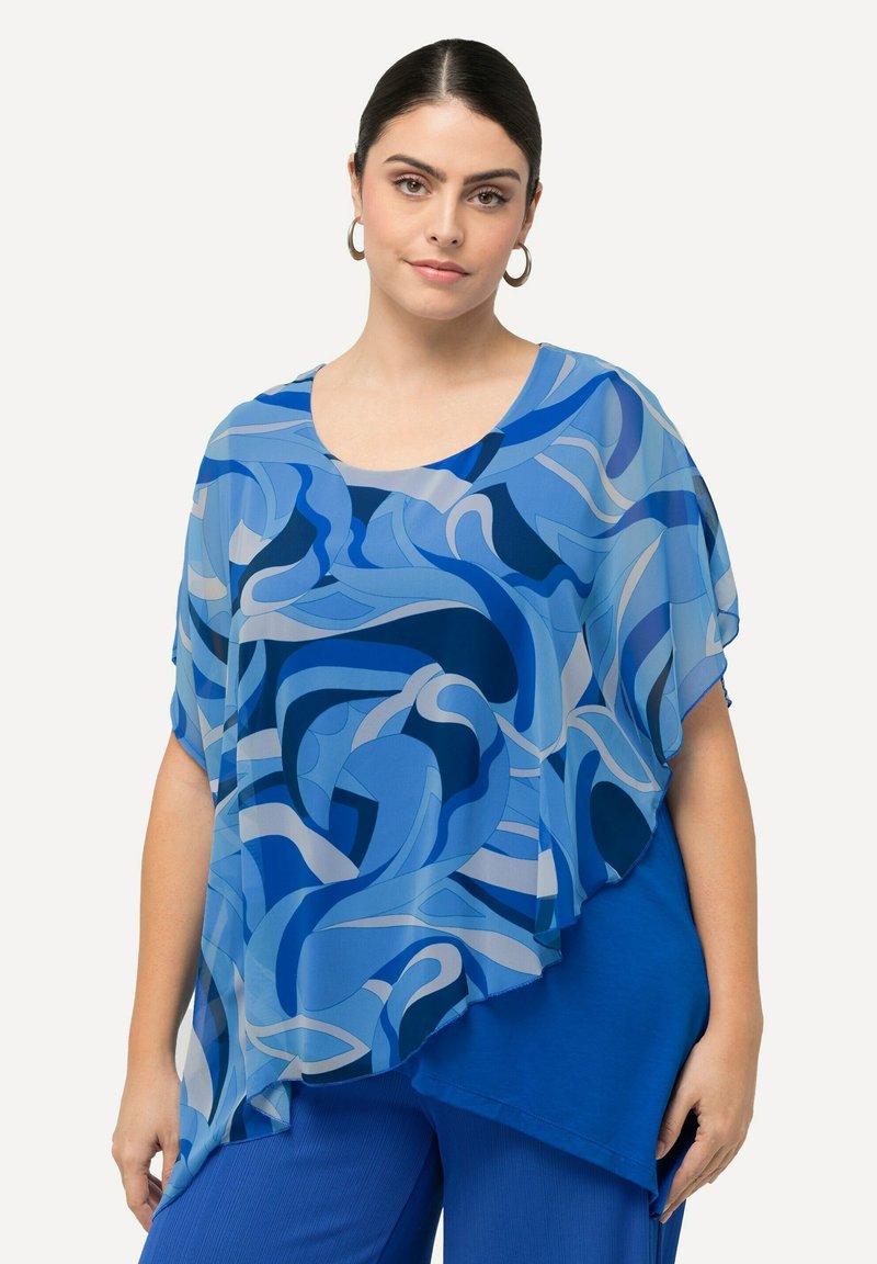 Top blu con motivo a fantasia, dal design fluido e leggero. Caratterizzato da diverse tonalità di blu, motivi astratti a onda e scollatura a giro.