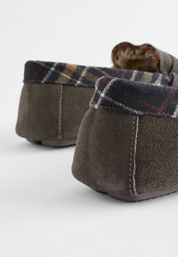 Bruine suède slippers met een gestructureerde achterkant, voorzien van een kraag van ruitenstof in marineblauw, bruin en gele tinten. Zachte voering zichtbaar.