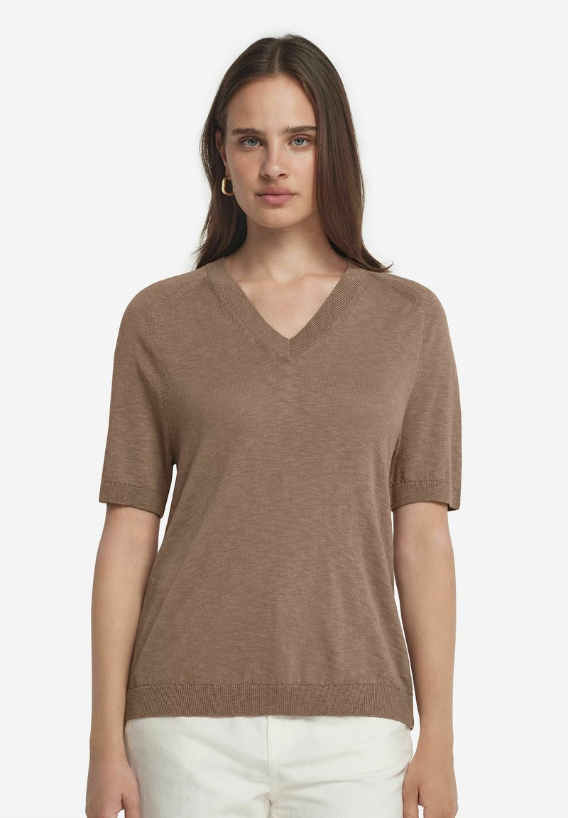 Brun kortärmad V-ringad tröja gjord av ett mjukt, strukturerat material; har en avslappnad passform och ribbade detaljer vid kragen och ärmsluten.