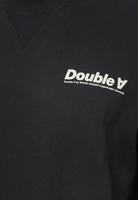 Μαύρη ζακέτα με ραμμένο λαιμό ribbed, κεντημένο λευκό λογότυπο "Double V" στο μπροστινό μέρος και υφή στην επιφάνεια.