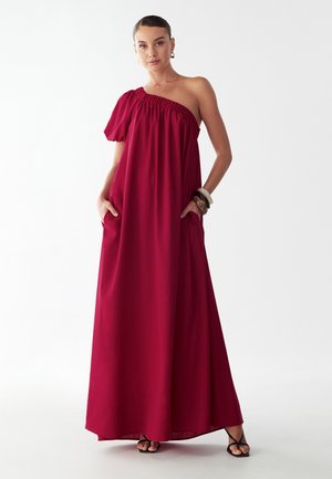 Bordová maxi šaty s jedným ramienkom, elastickým výstrihom, bočnými vreckami a mäkkou, splývavou látkou.