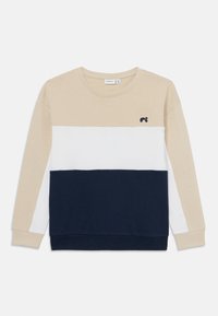 Beige, hvit og marineblå fargeblokkert sweatshirt med ribbet tekstur, rund hals og liten logo på øvre venstre side. Lange ermer.