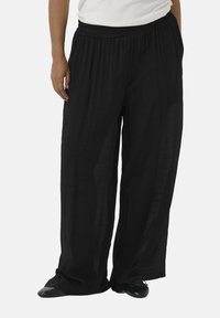 Pantalones anchos, ligeros y negros con una cintura elástica y un tejido texturizado que cae de manera suelta. Adecuados para vestimenta casual.