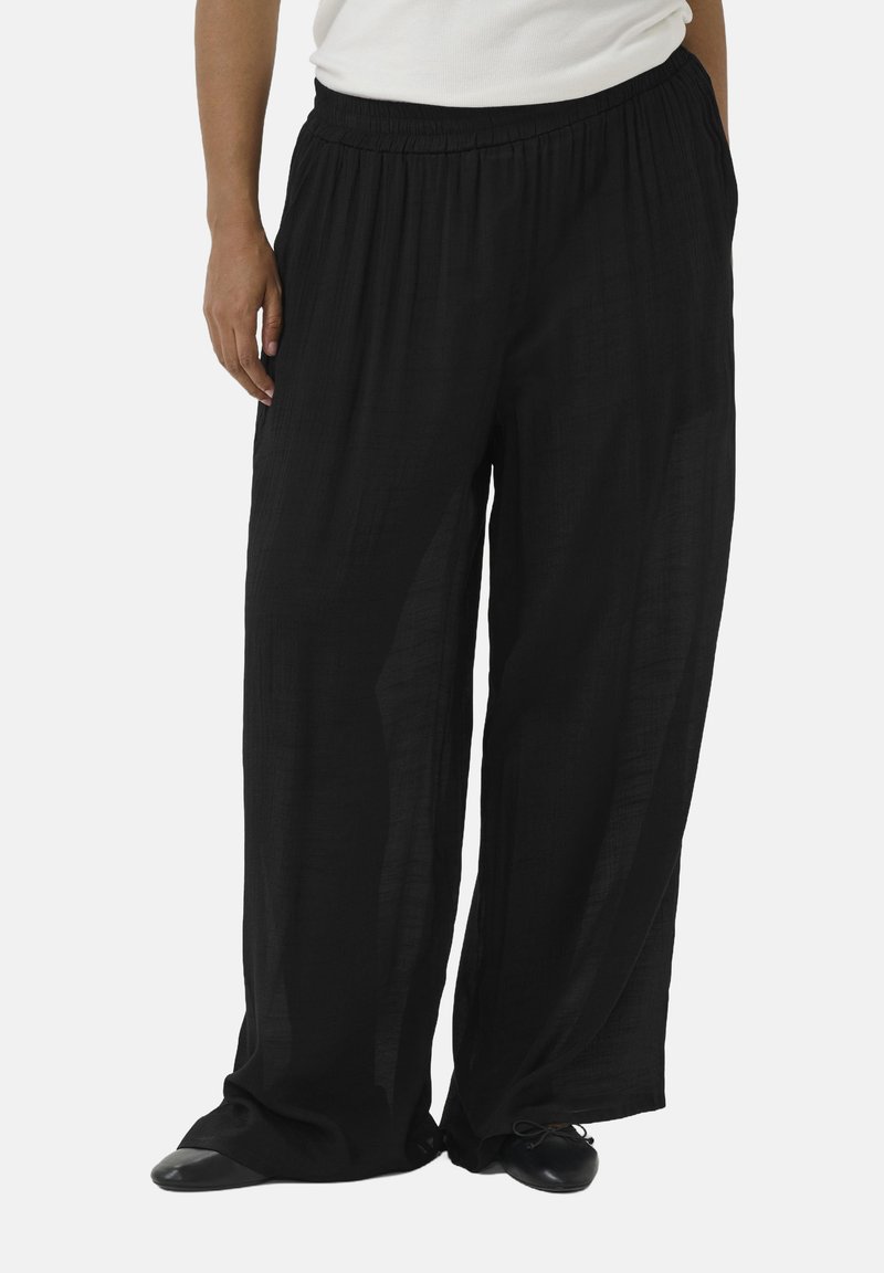 Pantalones anchos, ligeros y negros con una cintura elástica y un tejido texturizado que cae de manera suelta. Adecuados para vestimenta casual.