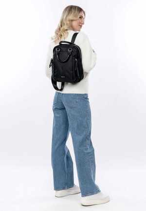 Zaino in nylon nero con doppie spalline, maniglia superiore e tasche con zip. Texture liscia e design minimalista.