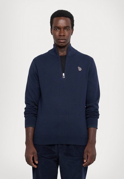 Maglione a mezza zip di colore blu navy realizzato in tessuto a maglia, con polsini a coste e un piccolo logo ricamato sul lato sinistro del petto.