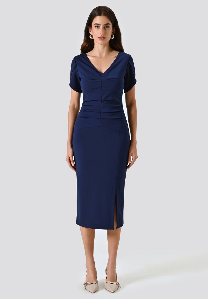 Marineblaues knielanges Kleid mit kurzen Puffärmeln, tiefem V-Ausschnitt, gerafftem Oberteil und Schlitz vorne. Glatter, strukturierter Stoff, figurbetonte Silhouette.