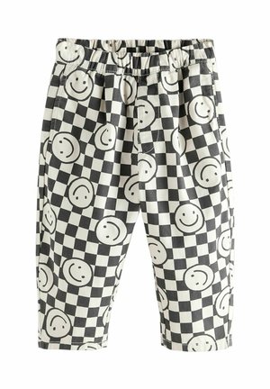 Mustvalged ruudulised püksid, millel on elastne vöökoht ja mis on kaunistatud võrdselt paigutatud mustade naerunägudega valgetel ruutudel.