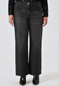 Wijde zwarte denim jeans met een vervaagde afwerking, voorzien van een klassiek vijf-pocket ontwerp, knoopsluiting en contrasterende stikseldetails.