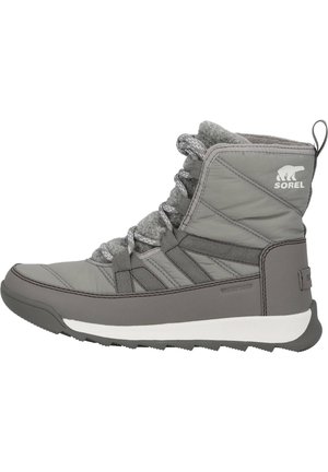 Botín gris de invierno con un exterior acolchado, tela texturizada, puntera reforzada y suela blanca. Incluye cordones grises y un logo de Sorel.