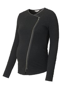 Top de maternidad negro de manga larga con tejido texturizado, que presenta un cierre diagonal y una forma ajustada que se adapta a la barriga en crecimiento.