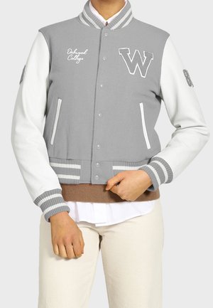 Grijze varsityjacket met witte leren mouwen, ribbelboorden en kraag. Bevat "Oakwood College" borduursel en groot "W" embleem.