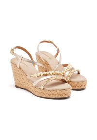 Sandales compensées beiges avec semelle en jute tressé, brides métalliques et perles décoratives. Comprend une bride de cheville ajustable et une semelle intérieure rembourrée.