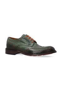 Groene leren veterschoen met oranje oogjes, brogue-details, rond neus en een bruine houten zool. Opvallende texturen en stiksels aanwezig.