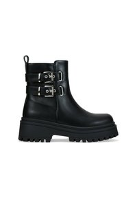Bota de tobillo de cuero negro con suela gruesa y dentada, dos correas con hebillas plateadas y tira de sujeción en la parte posterior, vista de lado.