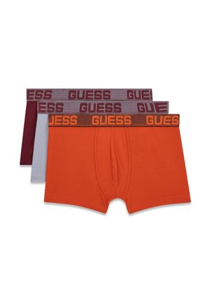 Trois boxers pour hommes en orange, gris clair et bordeaux avec des ceintures élastiques de marque "GUESS" aux couleurs contrastées.