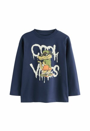 Navyblaues Langarm-T-Shirt mit einem Grafikdesign eines cartoonhaften Krokodils in einer Mütze, versehen mit dem Text "Cool Vibes" im weißen, tropfenden Malstil.