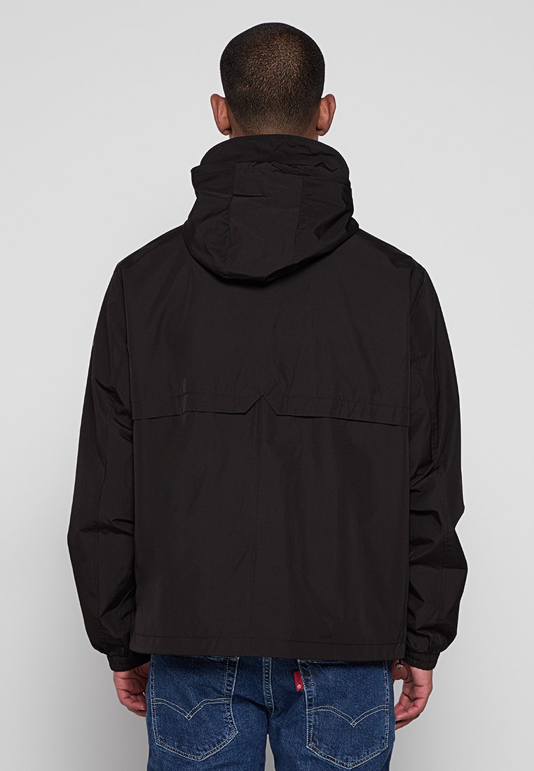 Zwarte hoodiejack met een gladde textuur, voorzien van een ritszak op de rug en een losse pasvorm. Het ontwerp heeft een rechte zoom en verlengde schouders.